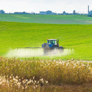 Sprühtraktor fährt über Wiese